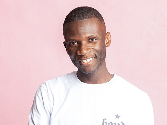 Man wearing a white shirt smiles at the camera