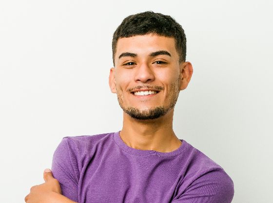Man smiles at the camera with his arms crossed